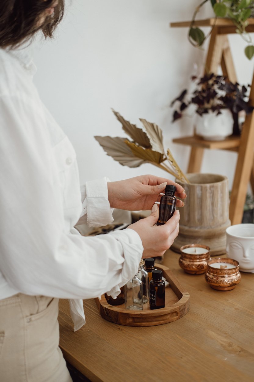 Woman Preparing Bottles of Scented Oil for Candle Making